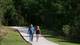 Walkers enjoy a concrete paved path in Cypress Creek Park.